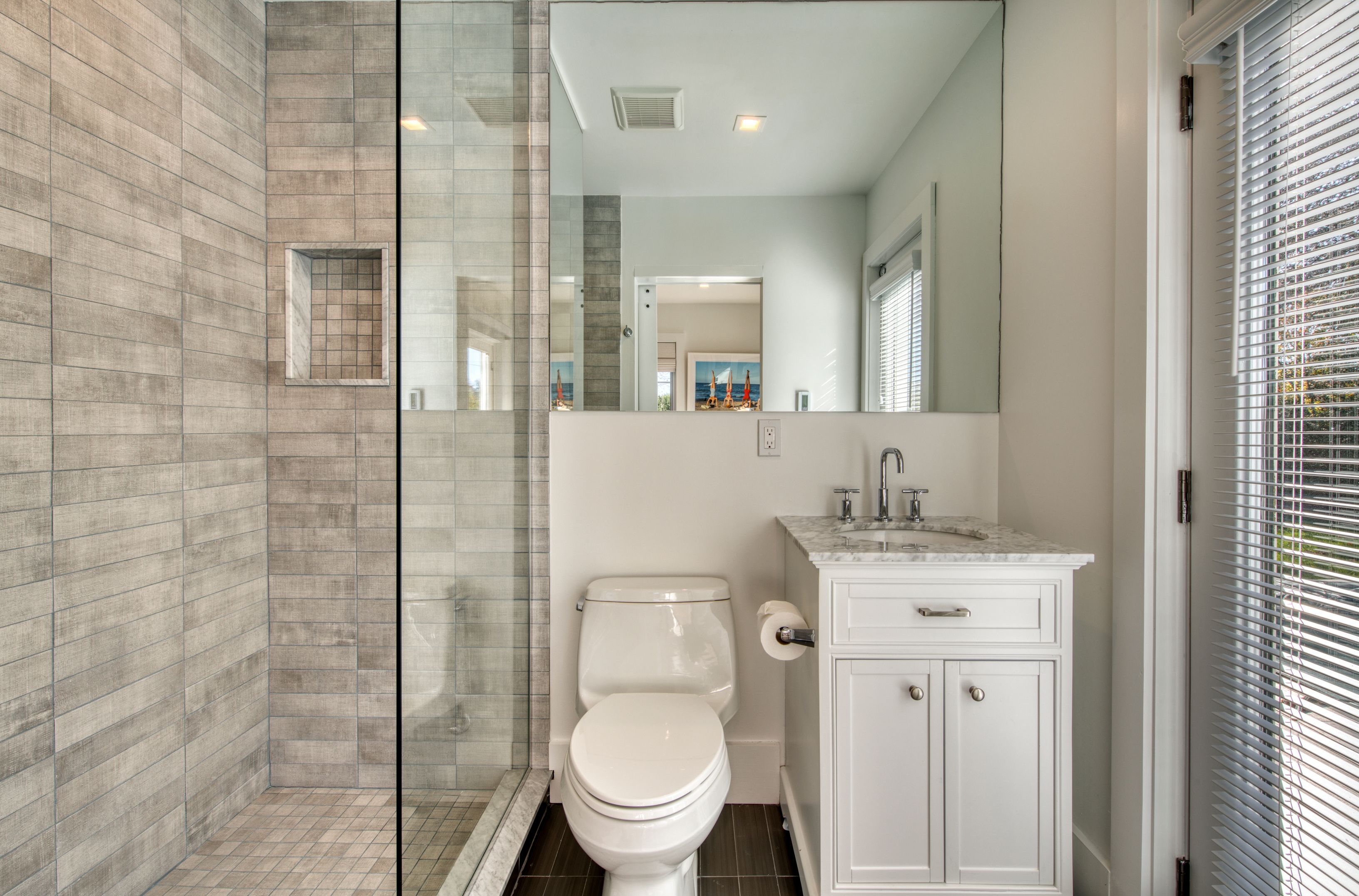 225 Oak Street Bridgehampton, NY 11932 - Photo 18 of 26 a bathroom with a granite countertop toilet a sink a mirror and shower