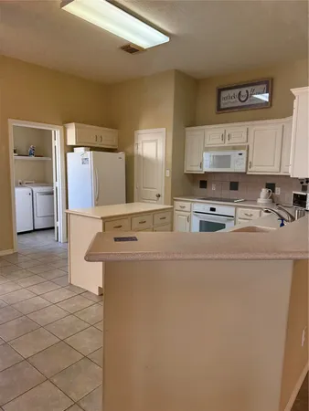 a kitchen with a sink window and cabinets