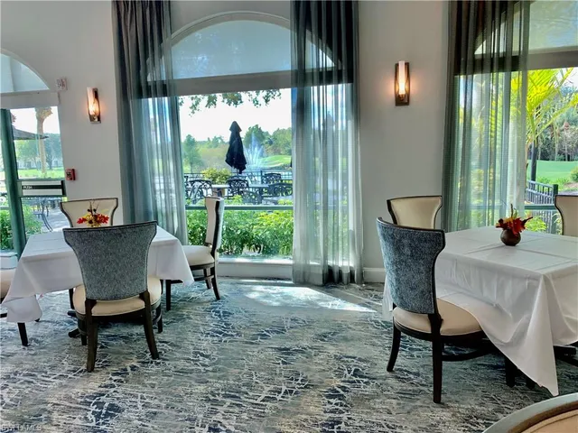 a dining room with furniture a rug and a floor to ceiling window