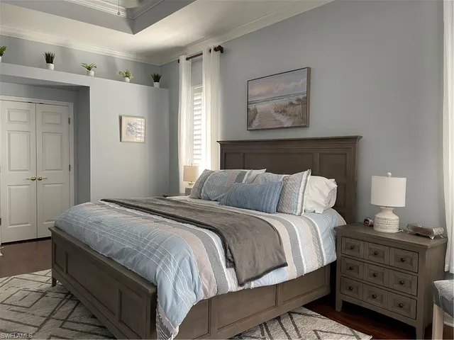 a bedroom with a bed and a lamp on dresser