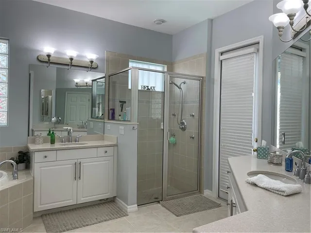 a bathroom with a granite countertop sink mirror and shower