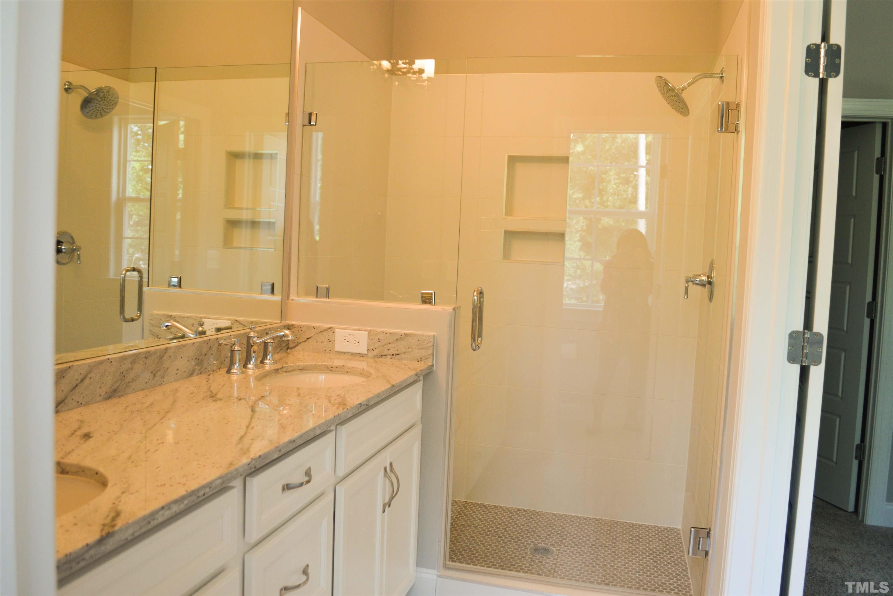 849 Wake Towne Drive Raleigh, NC 27609 - Photo 11 of 17 a bathroom with a granite countertop sink mirror and a shower