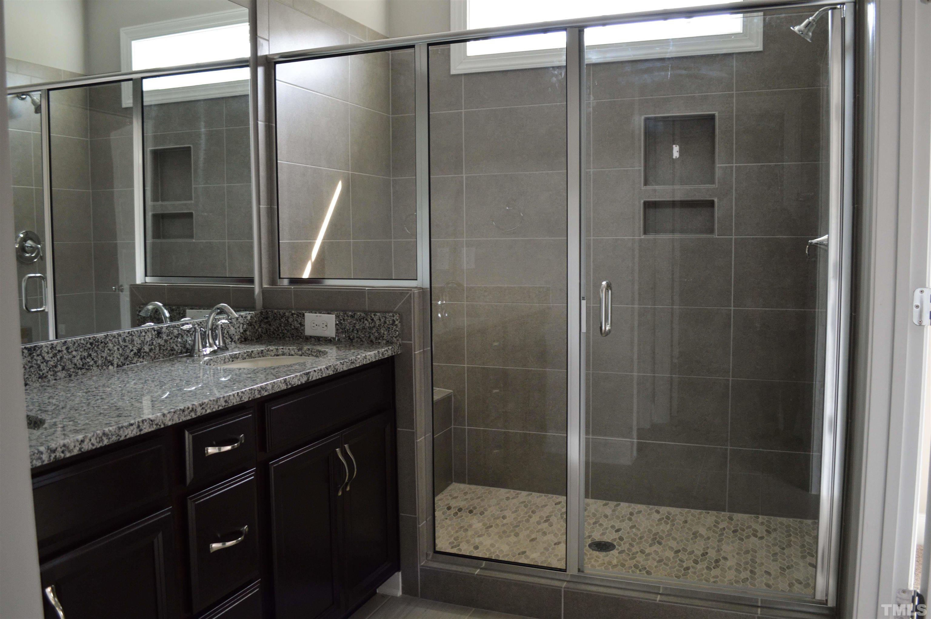 849 Wake Towne Drive Raleigh, NC 27609 - Photo 15 of 17 a bathroom with a granite countertop shower sink and mirror