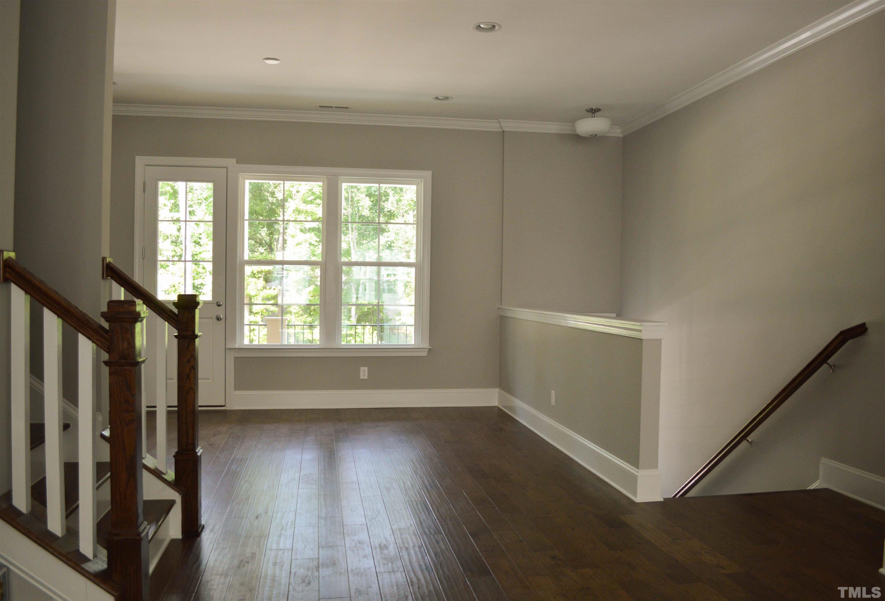 849 Wake Towne Drive Raleigh, NC 27609 - Photo 3 of 17 a view of an empty room with wooden floor and a window