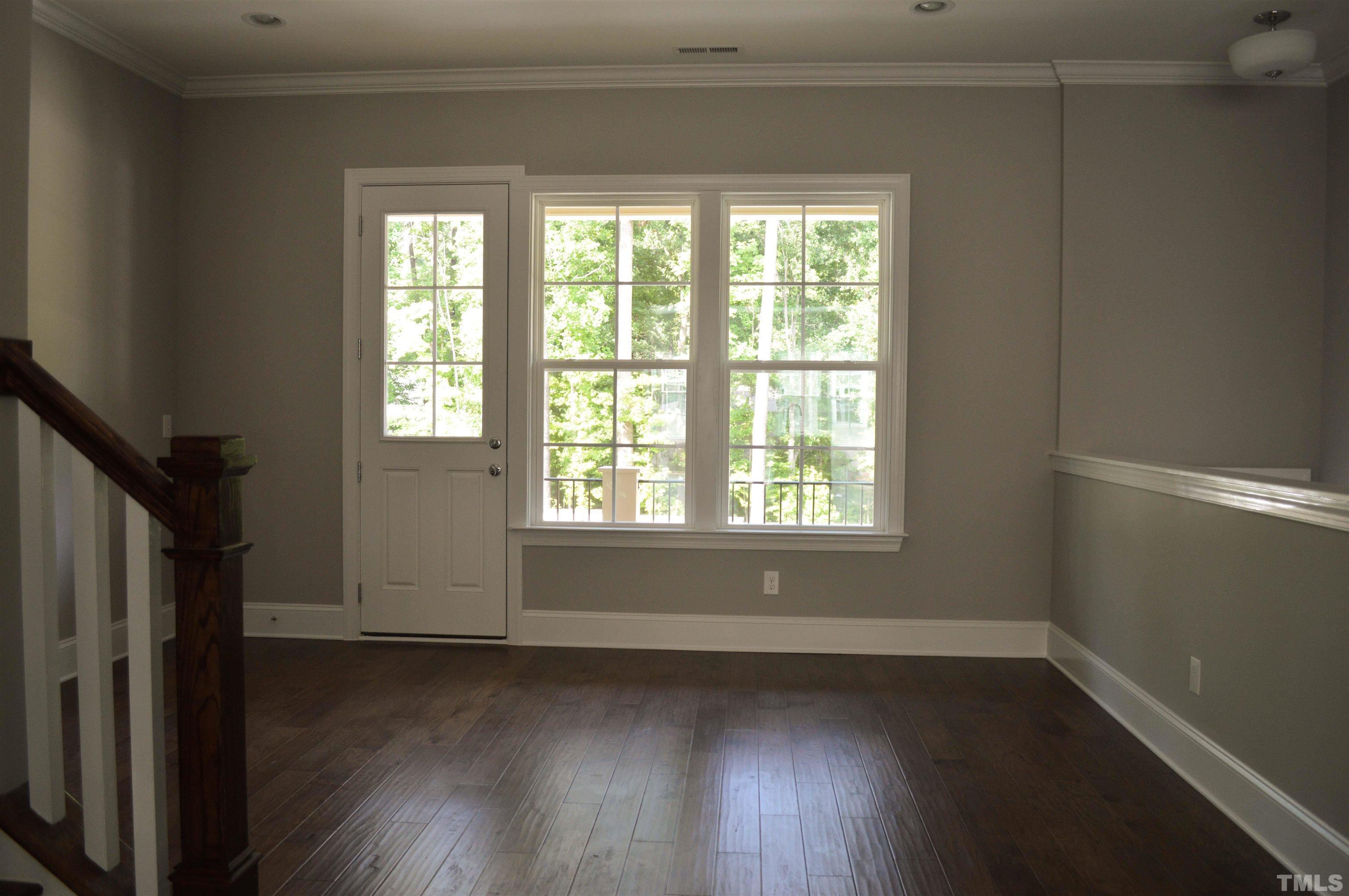 849 Wake Towne Drive Raleigh, NC 27609 - Photo 4 of 17 a view of an empty room with wooden floor and a window