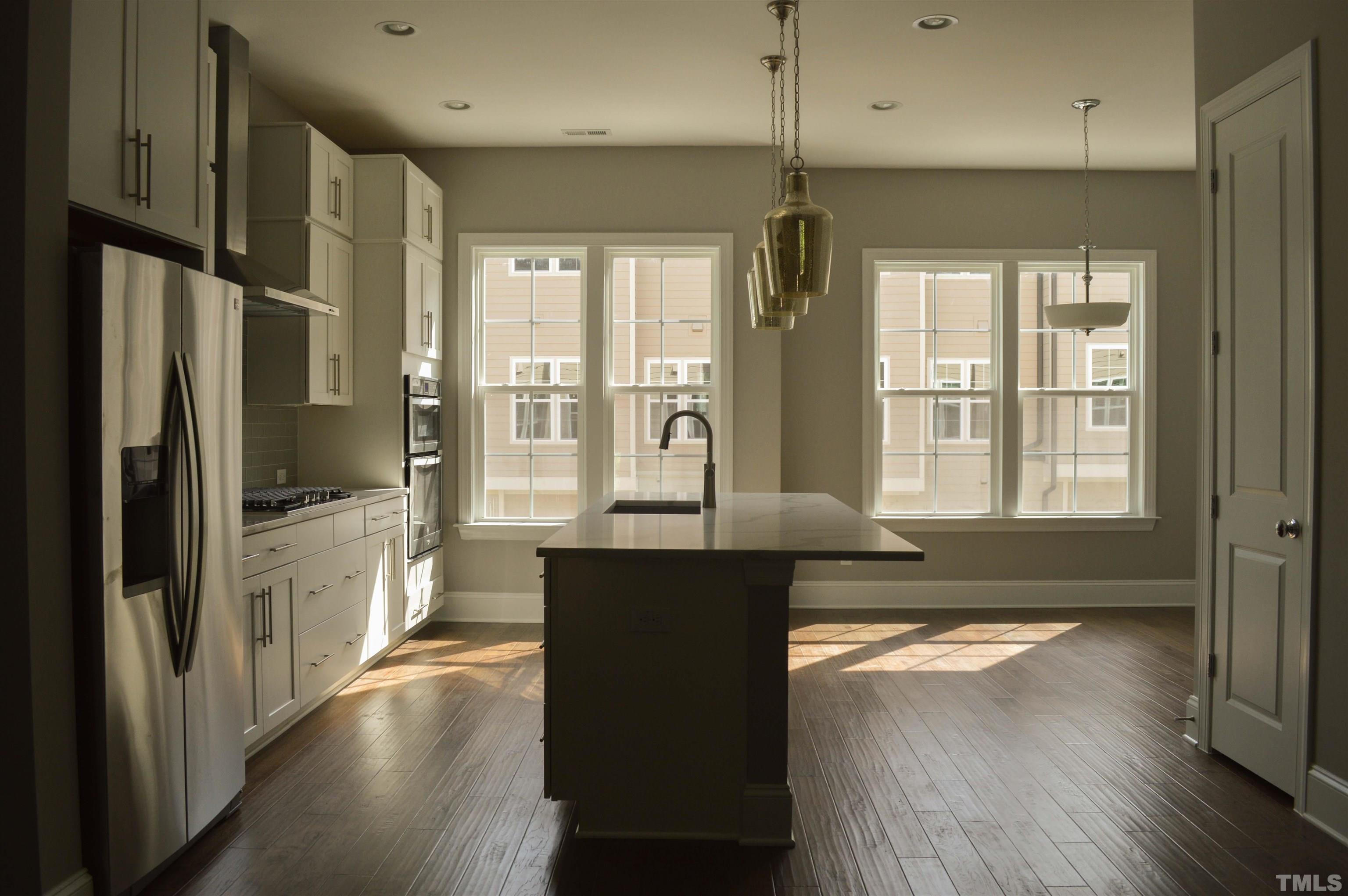 849 Wake Towne Drive Raleigh, NC 27609 - Photo 5 of 17 a large kitchen with stainless steel appliances a large counter top a stove a refrigerator and a sink