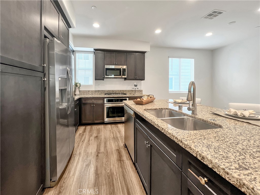 7418 Solstice Place Rancho Cucamonga, CA 91739 - Photo 6 of 18 a kitchen with a sink stove and refrigerator