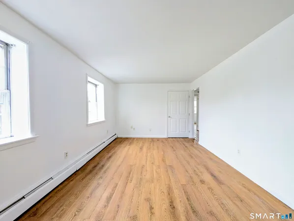 a view of empty room with wooden floor