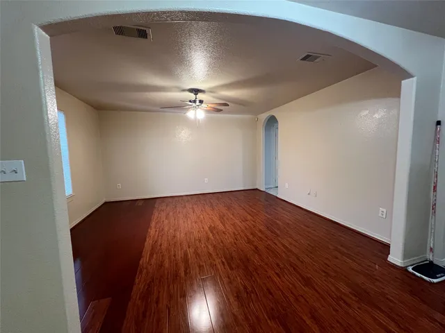 a view of an empty room with wooden floor