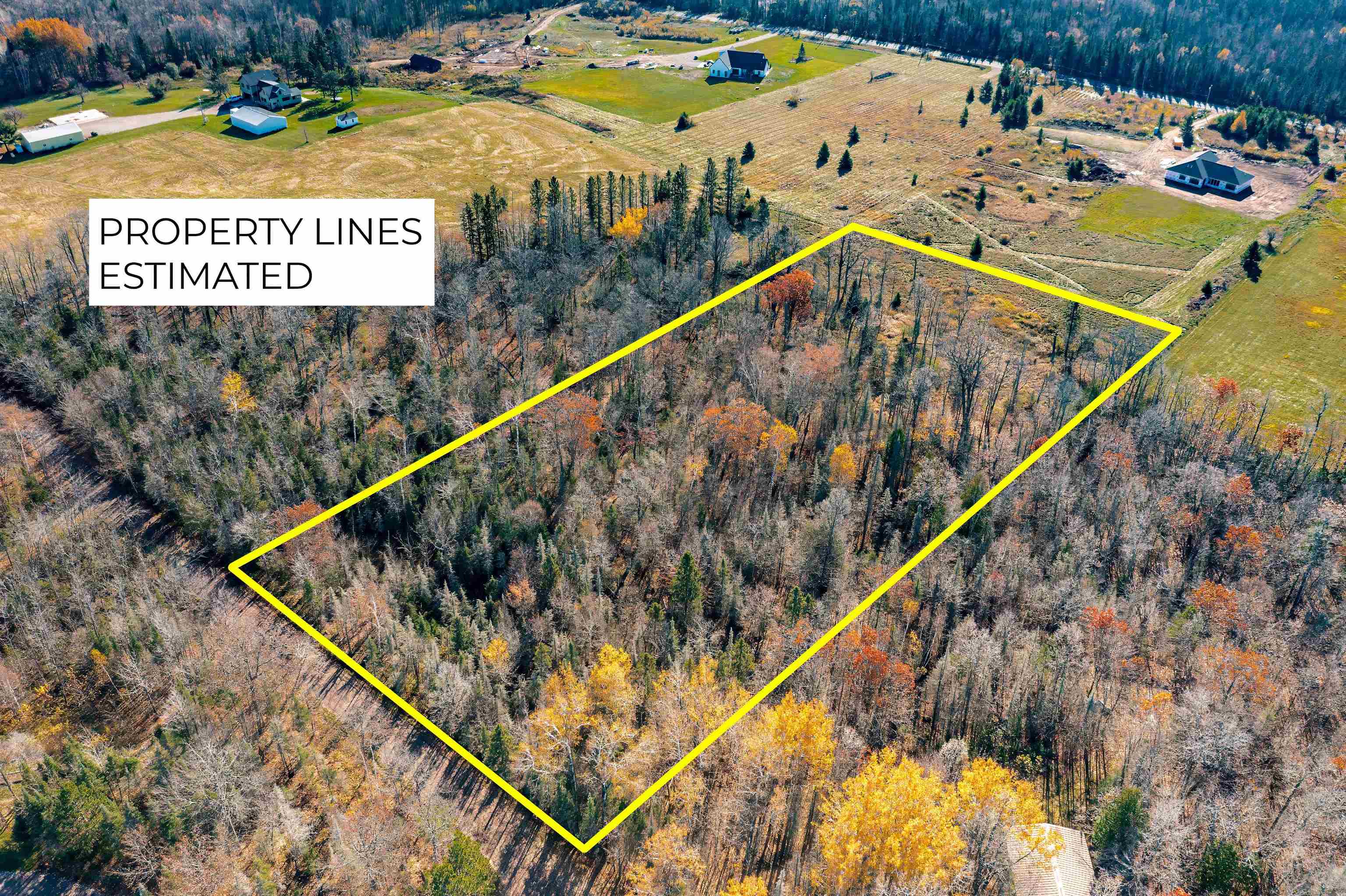 Aerial view of sparsely populated area featuring property parcel outlined