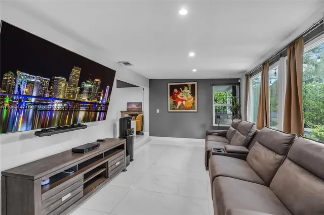 a living room with furniture a flat screen tv and a window