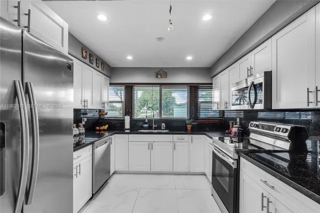 a kitchen with a sink stainless steel appliances lots of counter top space