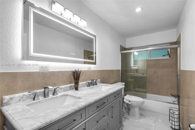 a bathroom with a granite countertop sink a toilet and a mirror