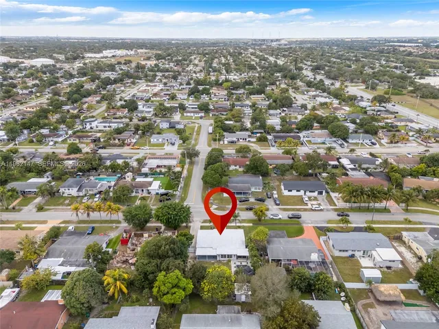 an aerial view of residential houses with outdoor space and parking