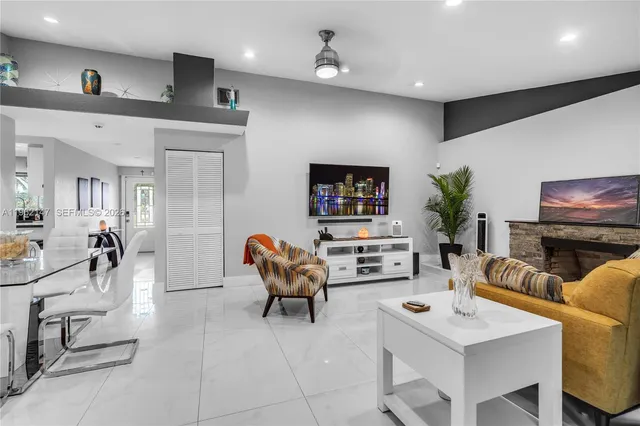 a living room with furniture a flat screen tv and kitchen view