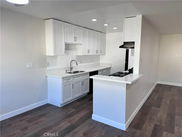 a kitchen that has a lot of cabinets and wooden floor