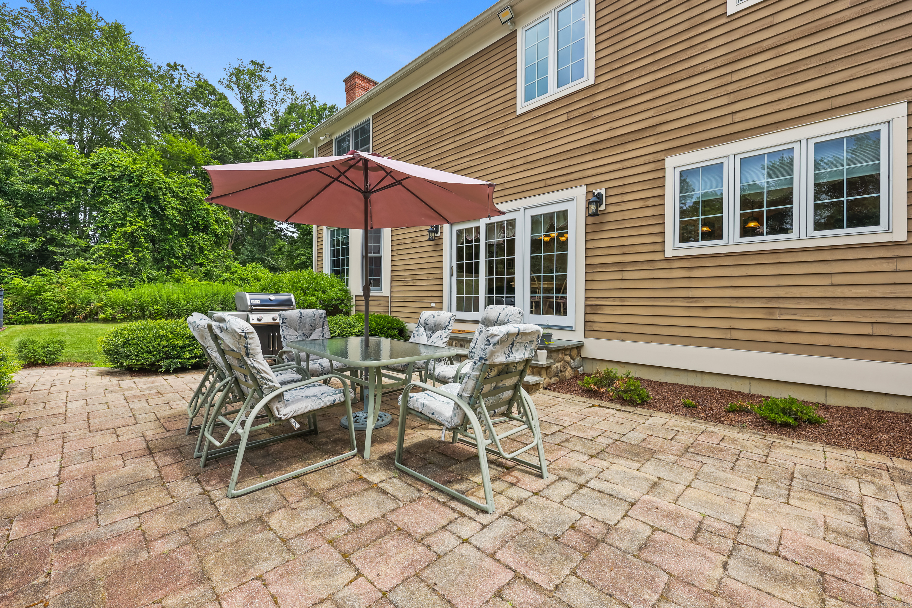 28 Sunnyview Drive Redding, CT 06896 - Photo 31 of 38 a patio with a table and chairs under an umbrella