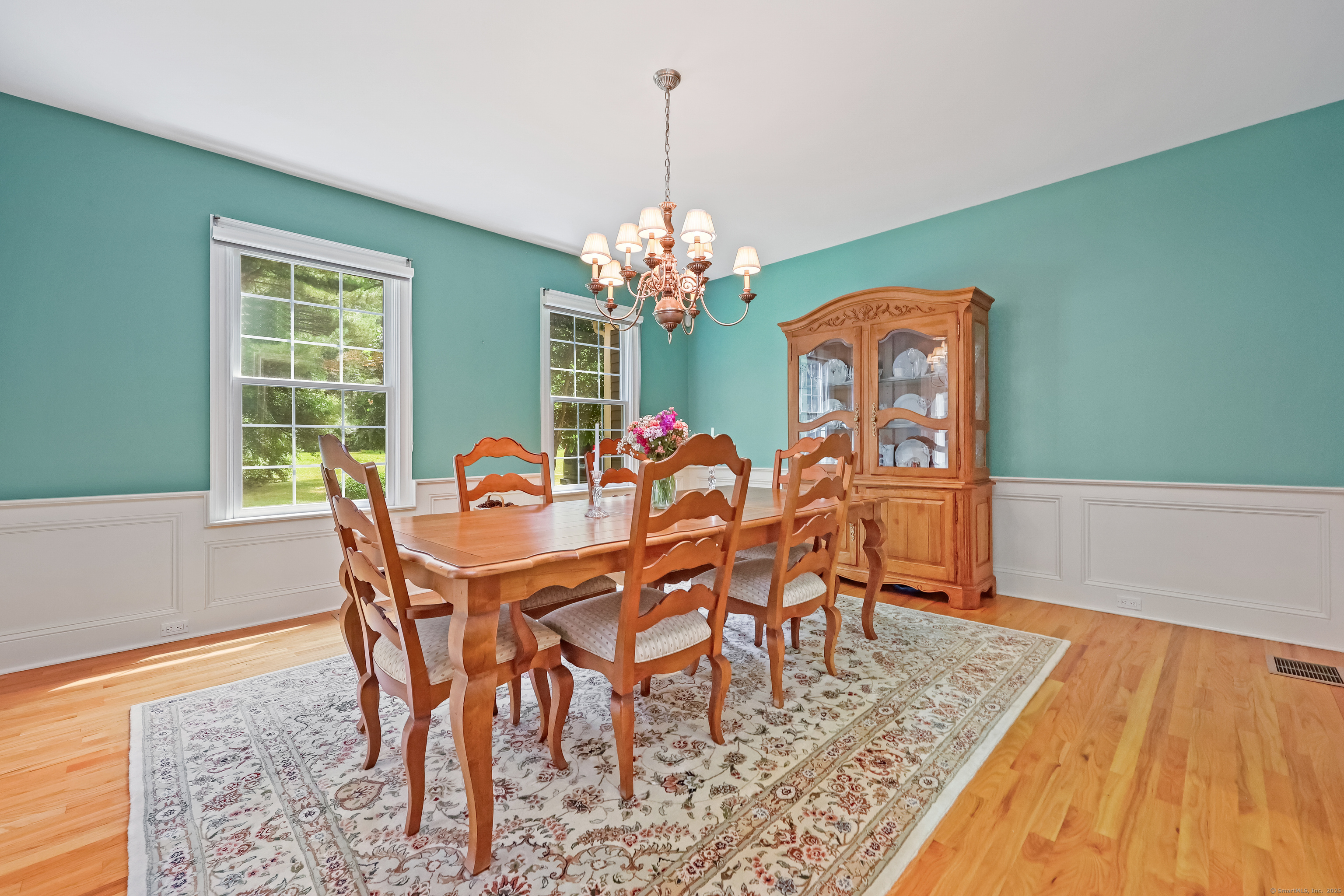 28 Sunnyview Drive Redding, CT 06896 - Photo 7 of 38 a dining room with furniture a rug and a chandelier