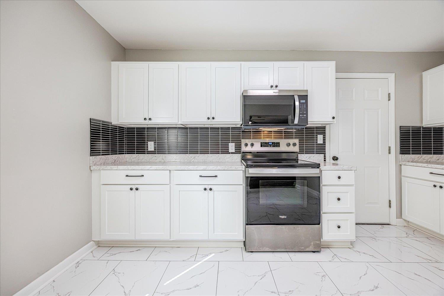 179 Harris Cove Collierville, TN 38017 - Photo 8 of 25 Kitchen featuring backsplash, appliances with stainless steel finishes, and white cabinetry