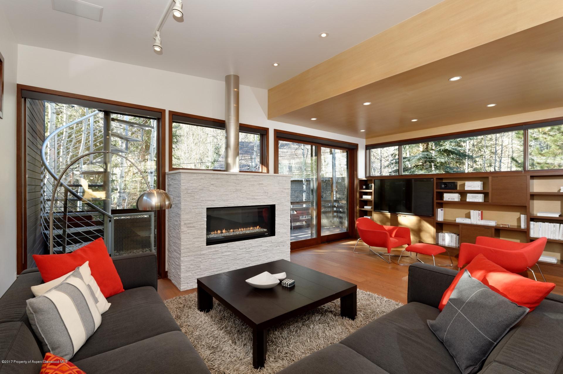 a living room with furniture fireplace and a large window