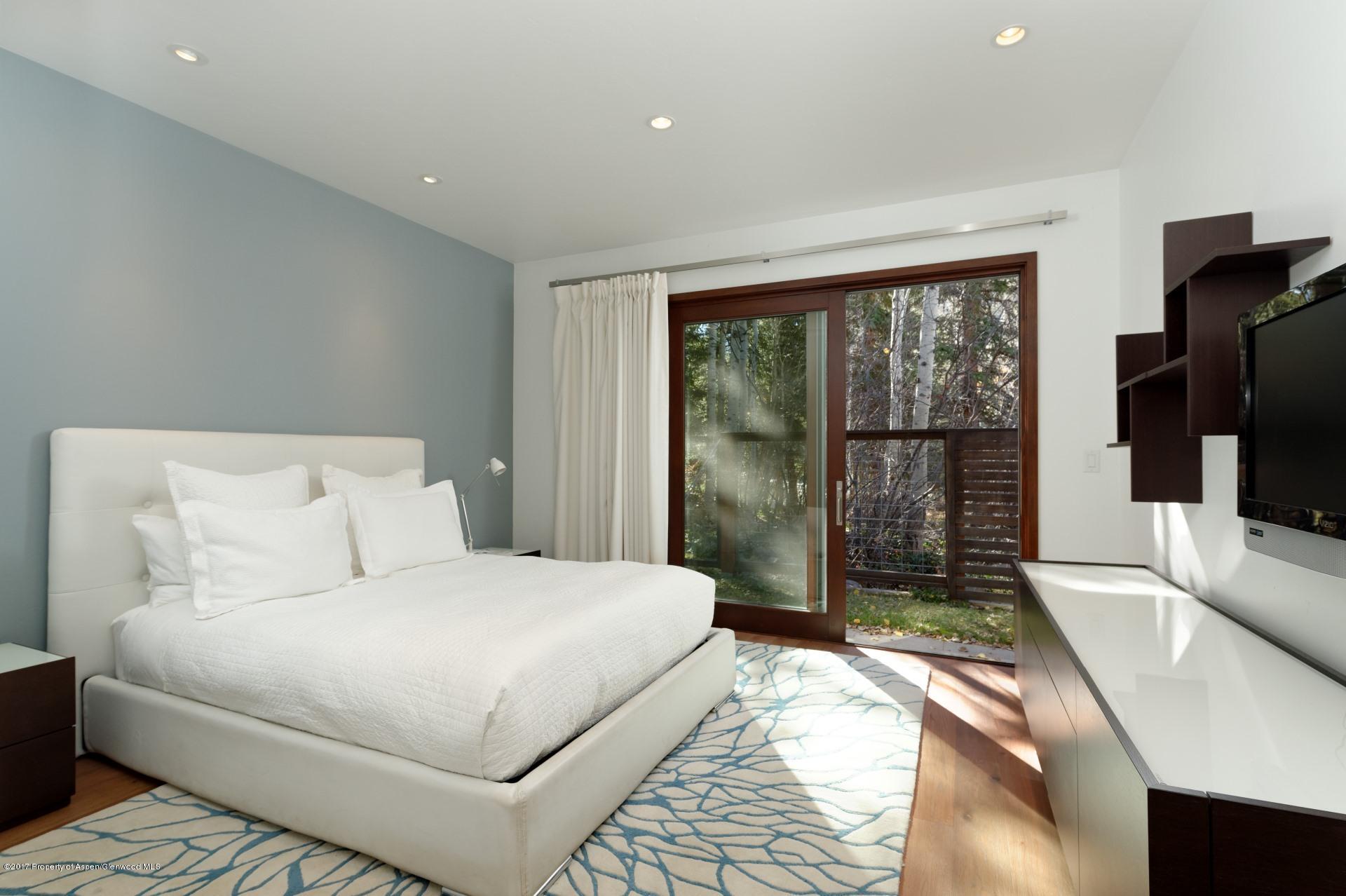 1291 Riverside Drive Aspen, CO 81611 - Photo 7 of 19 a bedroom with a large bed and a flat tv screen on dresser