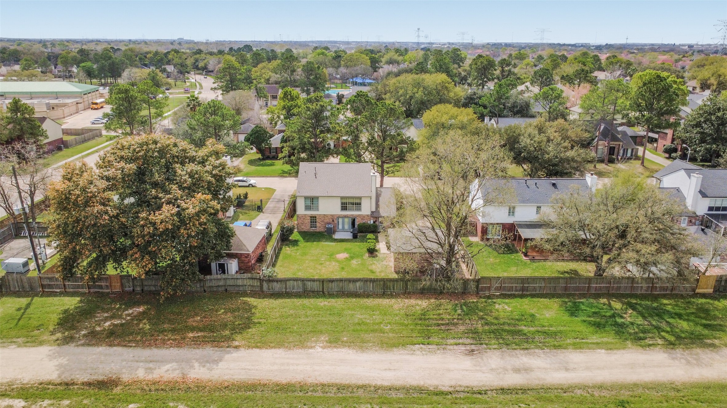10410 Dude Road Houston, TX 77064 - Photo 37 of 45 This aerial photo showcases a residential neighborhood with well-maintained homes and large trees. The houses are separated by fences, providing privacy, and the area appears green and spacious. A quiet road runs in front, adding to the peaceful suburban setting.