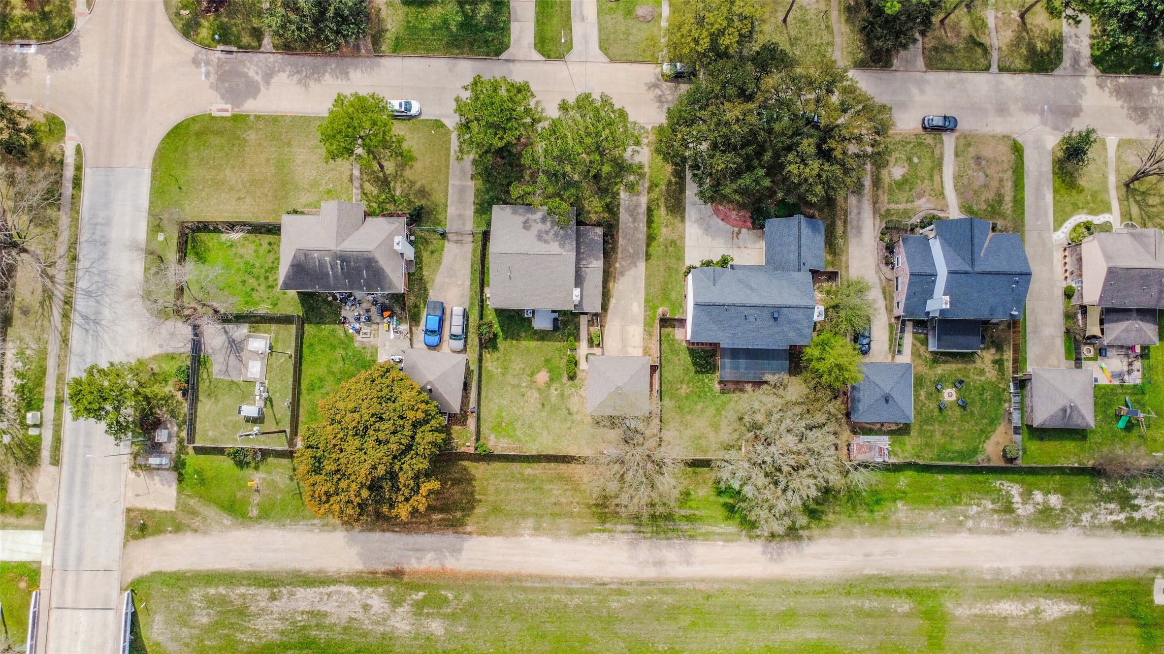 10410 Dude Road Houston, TX 77064 - Photo 38 of 45 This aerial photo showcases a neat neighborhood with single-family homes, each with a driveway and varying sizes of yards. The area is lush with trees, offering a suburban feel. The street layout is straightforward, providing easy access to each property.