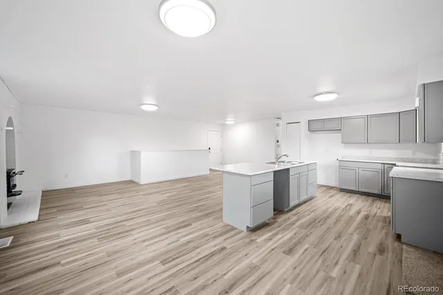a view of a kitchen with wooden floor and a sink
