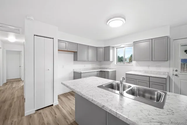 a kitchen with stainless steel appliances granite countertop a sink and a refrigerator