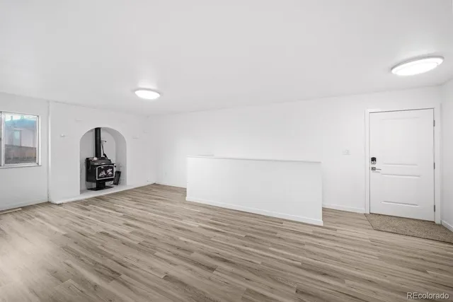 an empty room with wooden floor and window