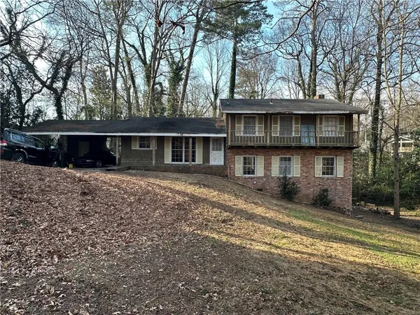 a view of a house with a large tree and a yard