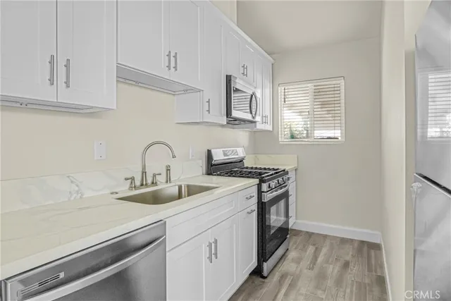 a kitchen with sink a stove and cabinets