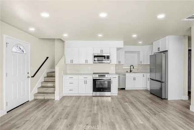 a kitchen with white cabinets and stainless steel appliances