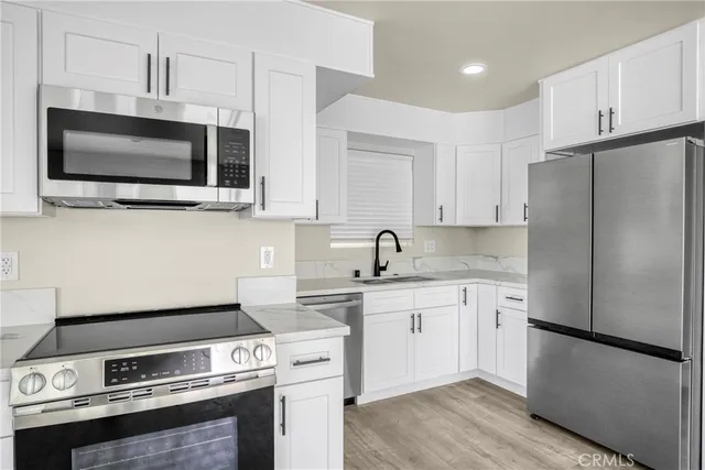 a kitchen with stainless steel appliances a stove microwave and sink