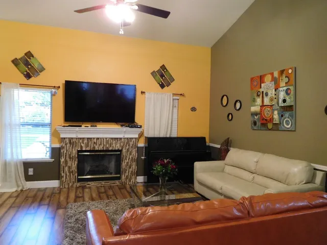 a living room with furniture a flat screen tv and a fireplace