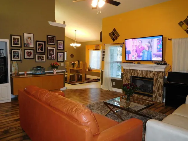 a living room with furniture a flat screen tv and a fireplace