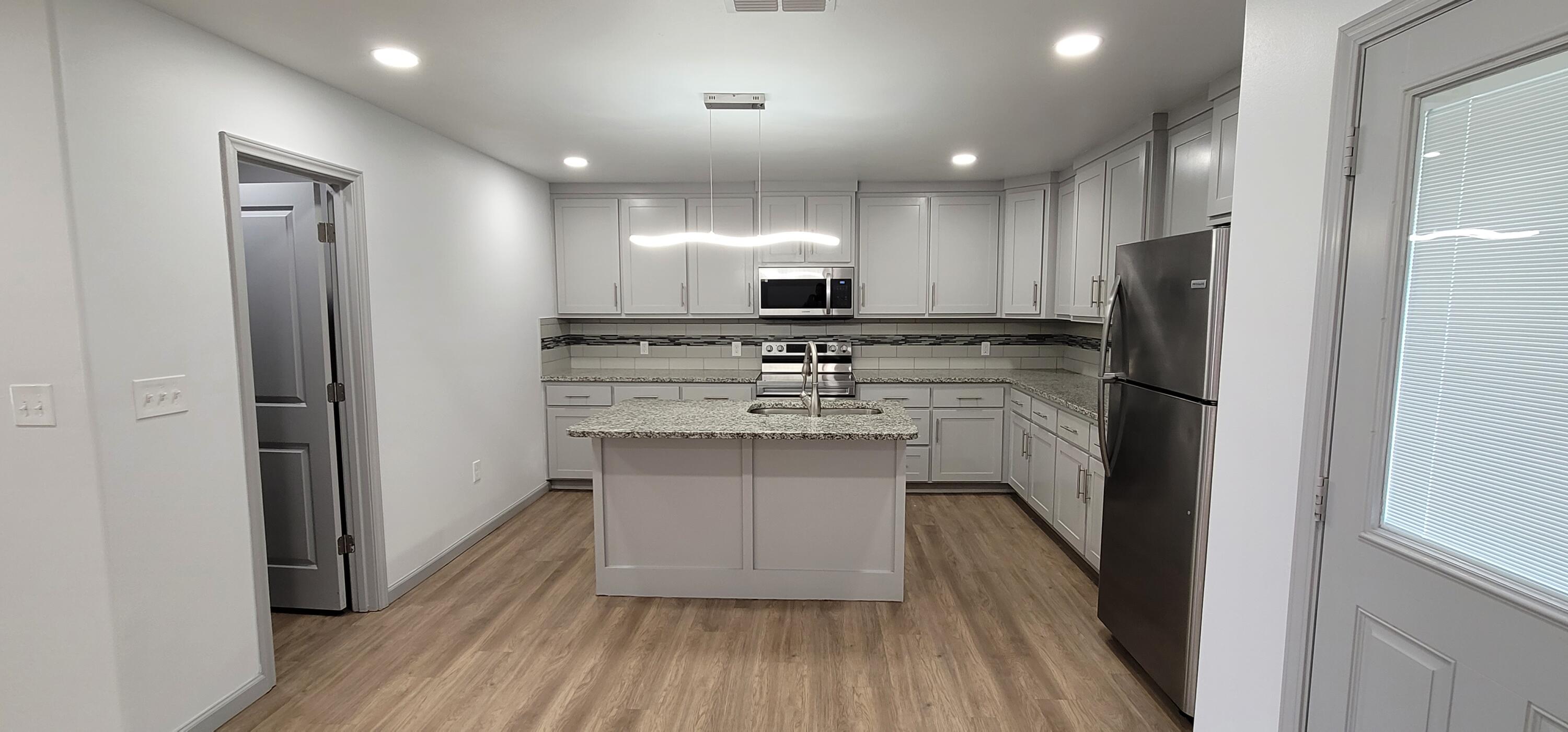 2110 88th Street Lubbock, TX 79423 - Photo 6 of 22 a kitchen with white cabinets and stainless steel appliances