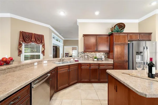 a kitchen with stainless steel appliances granite countertop a sink and dishwasher a refrigerator with wooden cabinets