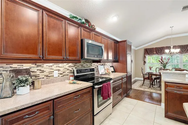 a kitchen with stainless steel appliances granite countertop a stove a sink and a microwave
