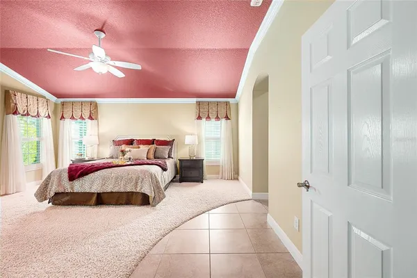a spacious bedroom with a bed and a chandelier