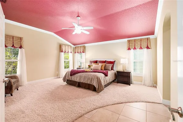 a bedroom with a large bed and a chandelier
