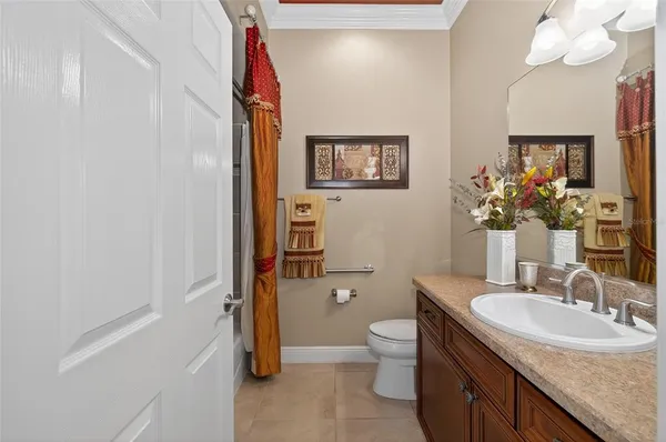 a bathroom with a granite countertop sink a toilet and mirror