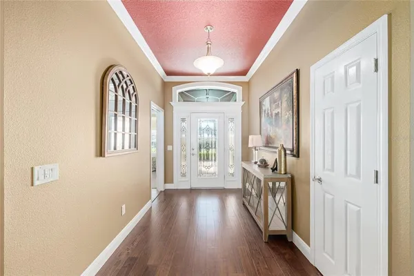 a view of a hallway with wooden floor and staircase