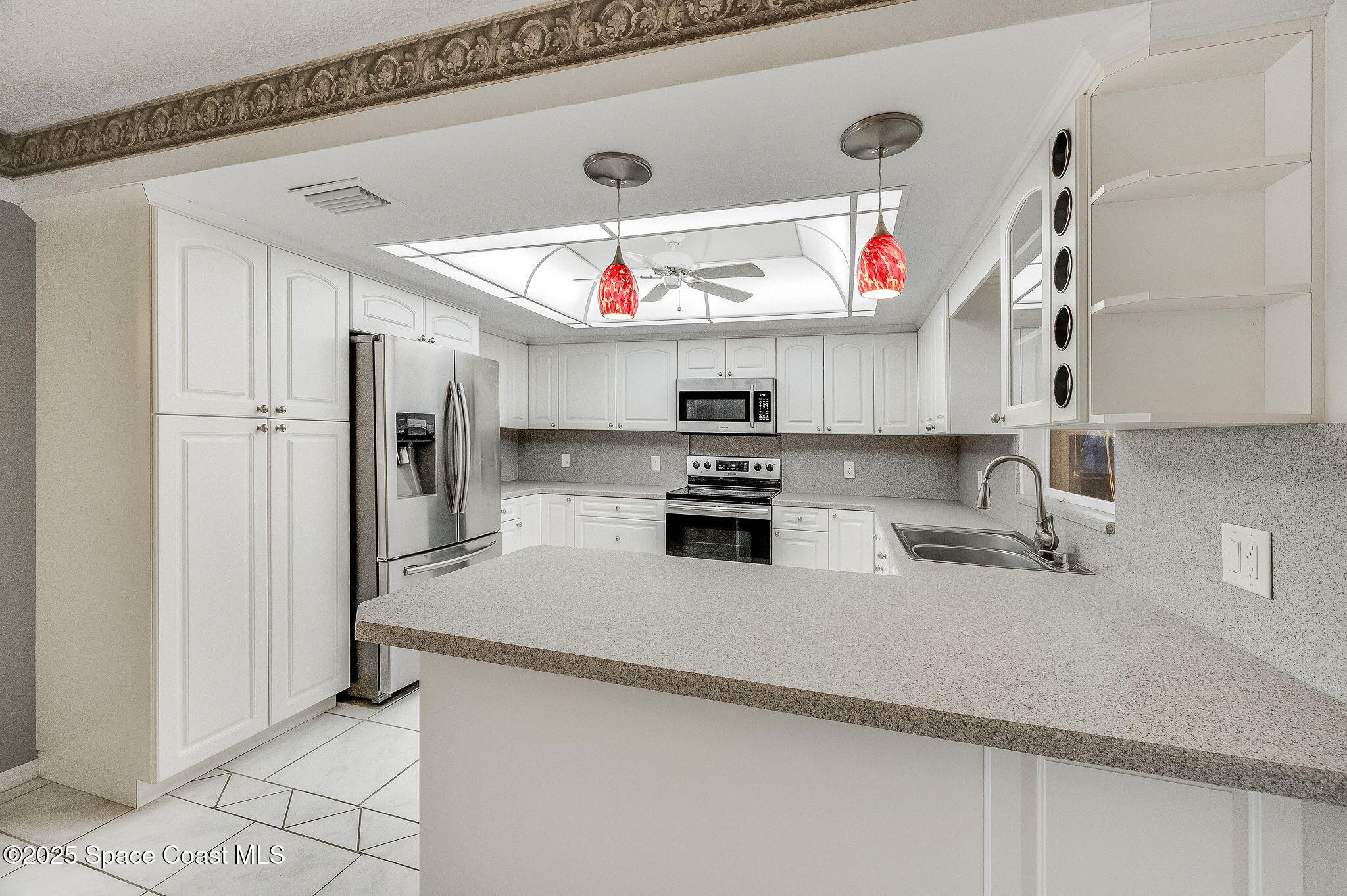 987 Sycamore Drive Rockledge, FL 32955 - Photo 13 of 48 a kitchen with stainless steel appliances granite countertop a sink a stove and a refrigerator