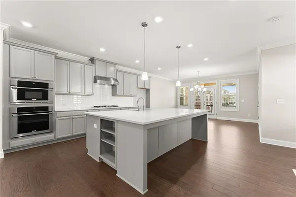 a large kitchen with stainless steel appliances kitchen island a large counter top and a stove top oven
