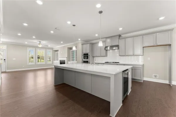a kitchen with a stove and a wooden floor