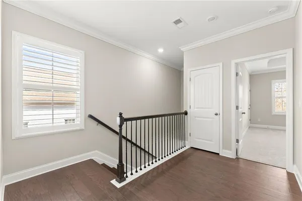 an empty room with windows and ceiling fan