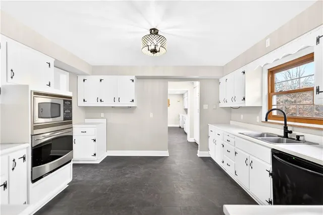 a kitchen with cabinets stainless steel appliances and a window