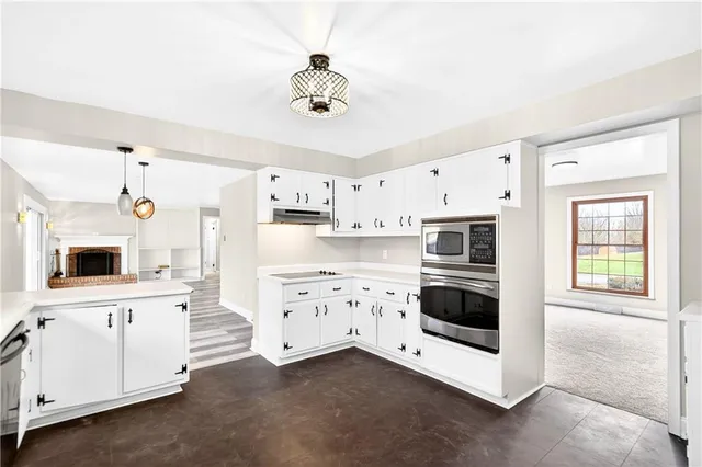 a kitchen with cabinets stainless steel appliances and wooden floor