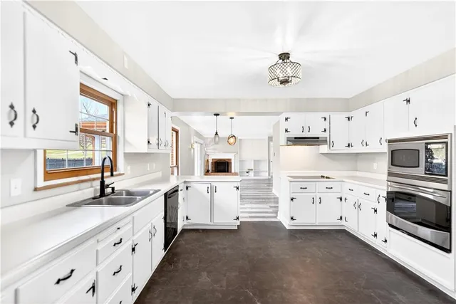 a kitchen with white cabinets and appliances